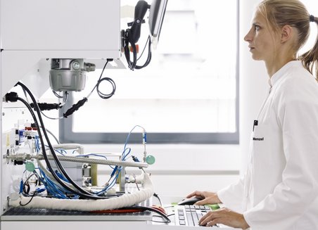 Eine Frau arbeitet im Stehen an einem Computer.